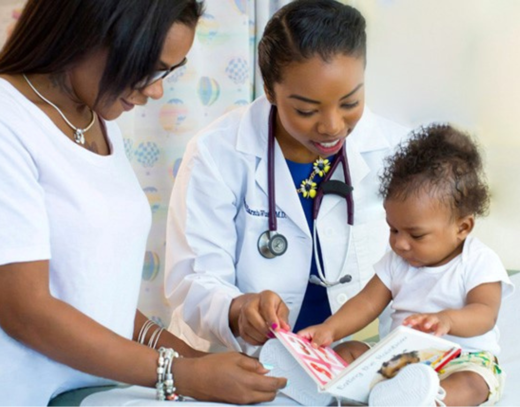 Doctor and child and parent engage with book during well child visit